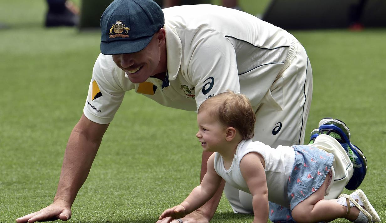 Wakil Kapten tim kriket Australia, David Warner bermain dengan anaknya usai laga melawan Selandia Baru di Brisbane, Australia, Senin (9/11/2015). (AFP Photo/Saeed Khan)