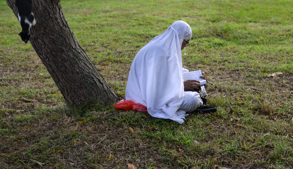 Seorang perempuan berdoa saat memperingati 18 tahun musibah gempa dan tsunami di kuburan massal Siron, Aceh, Senin (26/12/2022). Tsunami Aceh pada 2004 merenggut nyawa lebih dari 170.000 orang di Indonesia saja. (AFP/Chaideer Mahyuddin)