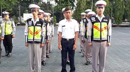 Pria bernama Polisi (Kemeja putih) berbaris dan anggota kepolisian di Polres Pasuruan (21/11). Sebelumnya, Polisi bekerja sebagai kuli bangunan. Akibat viral di medsos karena namanya yang unik, Polisi ditugaskan di Satlantas Polres Pasuruan. (AFP Photo)
