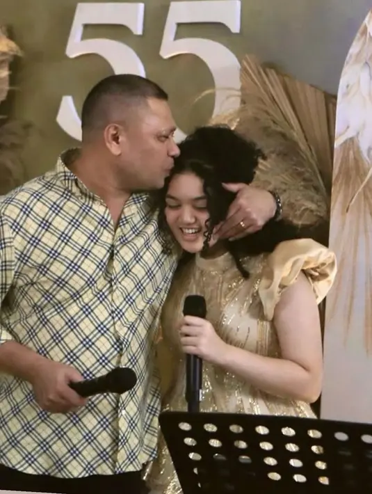 Busana Krisdayanti pun serasi dengan putrinya, Amora hanya berbeda model. Amora mengenakan atasan kerah tinggi lengan puff satin dipadukan rok tutu warna coklat. Rambut ikal hitam dikuncir setengah ke belakang. [@krisdayantilemos]