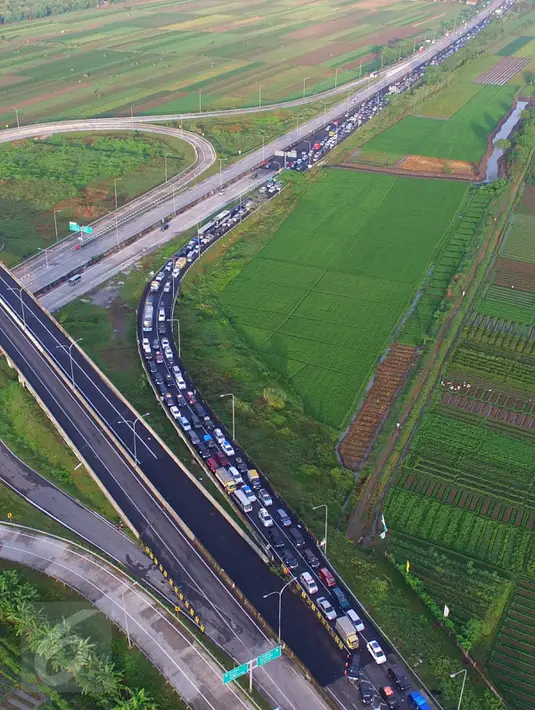 Pandangan udara kendaraan terjebak kemacetan saat keluar tol Pejagan, Jawa Tengah, Sabtu (2/7). Kemacetan panjang hingga 18 km terjadi dikarenakan antrean saat pembayaran pintu tol keluar. (Liputan6.com/Balgo Marbun)