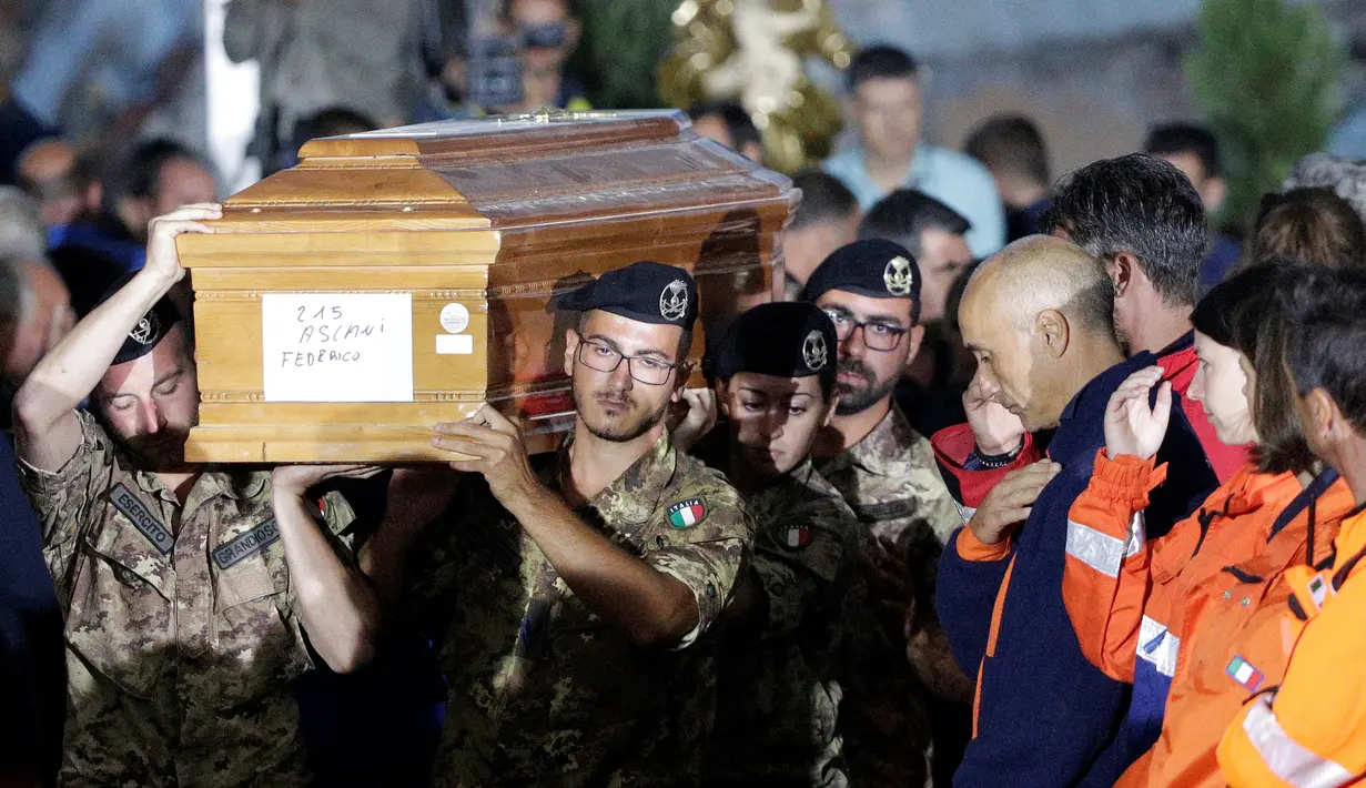 Tentara Italia menggotong peti mati pada upacara pemakaman korban gempa bumi yang meratakan kota di Amatrice, Italia tengah, Selasa (30/8). Hampir 300 orang tewas saat gempa bumi 6,2 SR melanda Amatrice dan sekitarnya 24 Agustus lalu. (REUTERS/Max Rossi)
