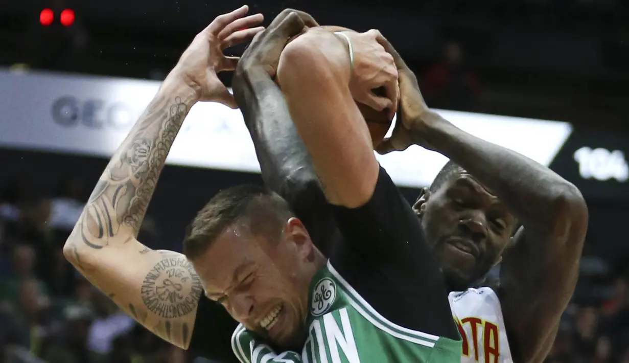 Pebasket Boston Celtics, Daniel Theis, berebut bola dengan pebasket Atlanta Hawks, Dewayne Dedmon, pada laga NBA di Philips Arena, Atlanta, Senin (6/11/2017). Hawks kalah 107-110 dari Celtics. (AP/John Bazemore)