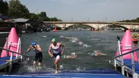 Para atlet berkompetisi di babak renang di Sungai Seine pada triathlon individu putra di Olimpiade Paris 2024 di pusat kota Paris pada 31 Juli 2024. (Anne-Christine POUJOULAT / AFP)