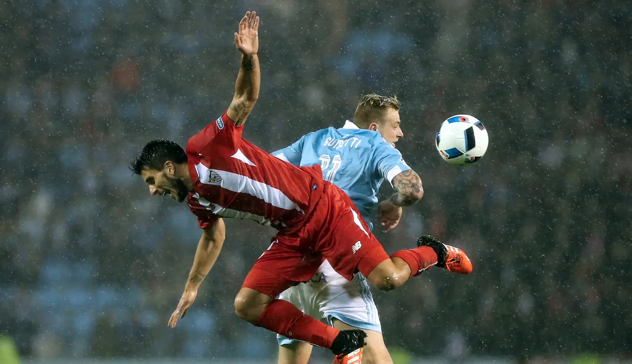 Pemain Sevilla, Daniel Carrico (kiri), berebut bola dengan pemain Celta Vigo, John Guidetti, dalam leg kedua semifinal Copa del rey di Stadion Balaidos, Vigo, Spanyol, Jumat (12/2/2016) dinihari WIB. (AFP/Cesar Manso)