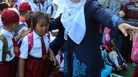 Seorang guru mengarahkan murid baru di hari pertama masuk sekolah di sekolah SDN 03, Pesanggrahan, Jakarta Selatan, Senin (16/7). Hari ini merupakan hari pertama masuk sekolah untuk tahun ajaran 2018-2019. (Merdeka.com/Arie Basuki)