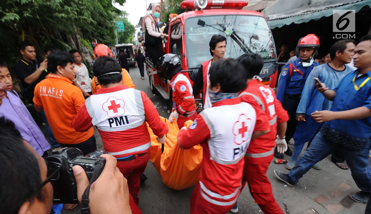 Petugas membawa kantuk jenazah korban rumah roboh di Jalan Pulo, Tanah Tinggi, Johar Baru, Jakarta Pusa, Jumat (26/4). Akibat kejadian tersebut mengakibatkan enam orang masih terjebak Korban selamat 4 orang dan yang meninggal 2 orang. (Liputan6.com/Herman Zakharia)