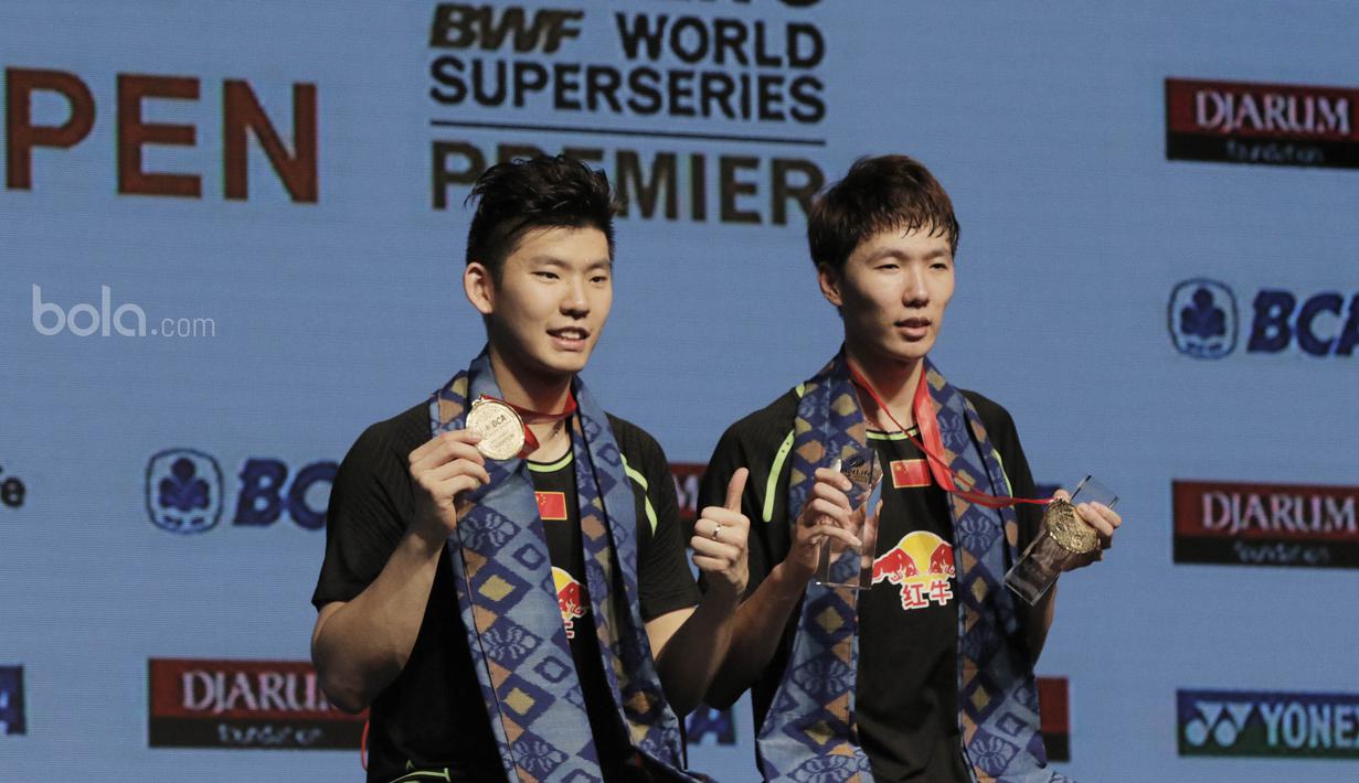 Pasangan China, Li Junhui/Liu Yuchen, menunjukan medali saat seremoni. Pasangan China tersebut  menang dengan skor 21-19 19-21 21-18. (Bola.com/M Iqbal Ichsan)
