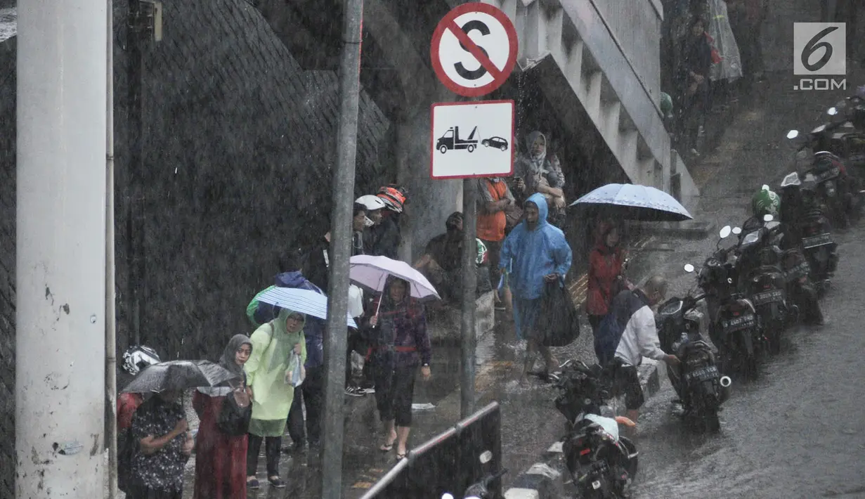 Pekerja dan pengendara berteduh saat hujan deras mengguyur kawasan Gatot Soebroto, Jakarta, Senin (11/2). Badan Meteorologi, Klimatologi, dan Geofisika (BMKG) memprediksi puncak musim hujan terjadi hingga Februari 2019. (Merdeka.com/Iqbal Nugroho)