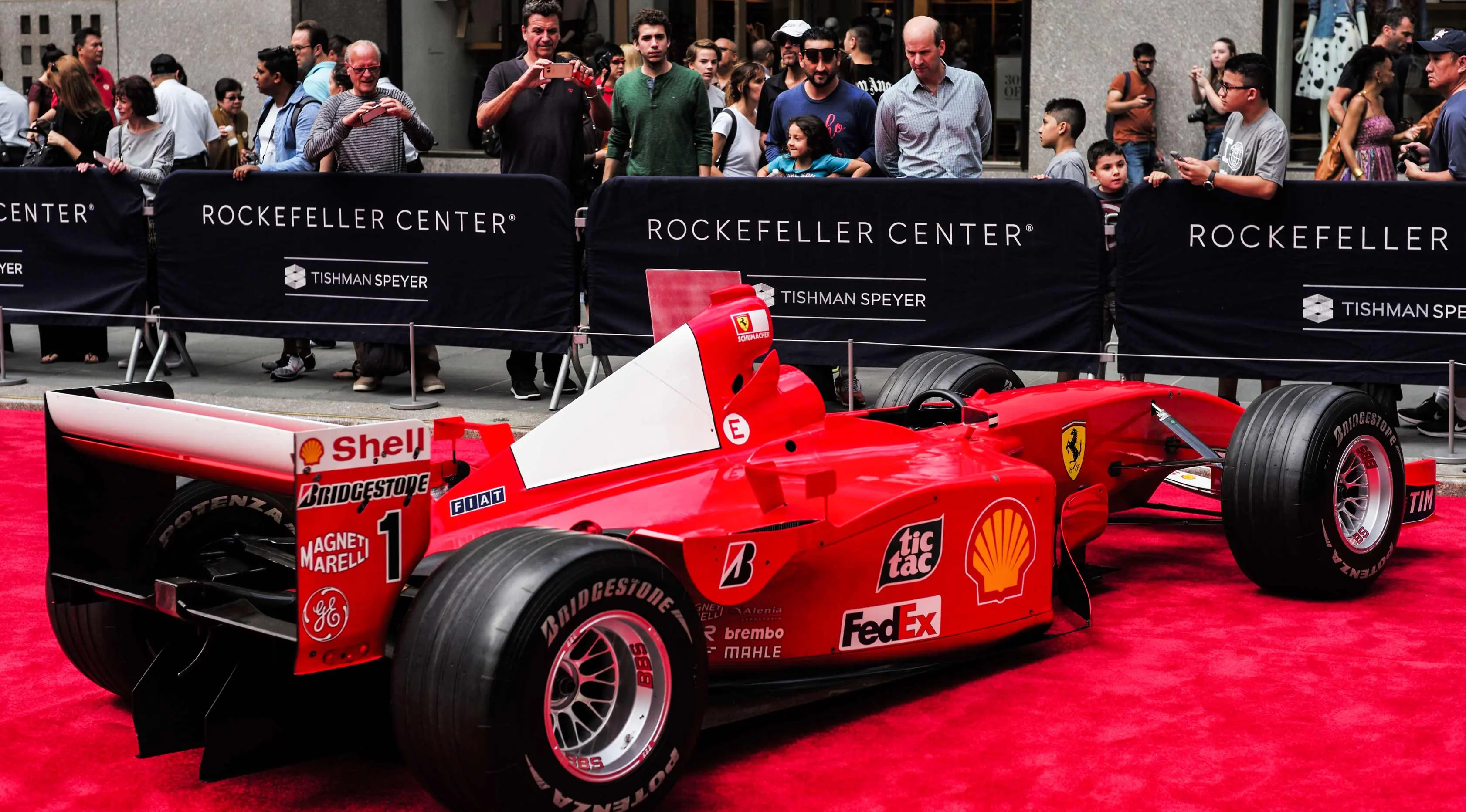 Pengunjung melihat mobil mantan pembalap Ferrari F1 dari Jerman, Michael Schumacher saat dipamerkan di perayaan ulang tahun Ferrari ke-70 di Rockefeller Plaza, New York, AS (8/10). (AFP Photo/Jewel Samad)