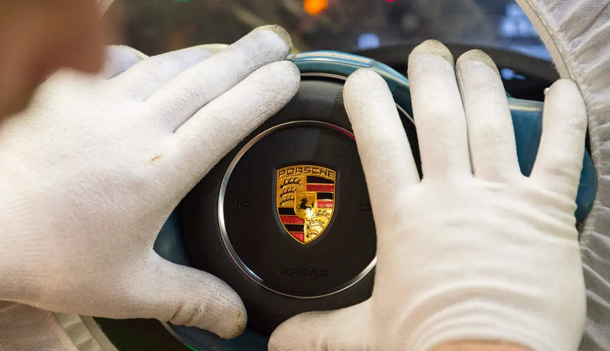 Karyawan merakit bagian kemudi mobil Porsche di pabrik Porsche di Stuttgart, Jerman (26/1). Untuk pemberian bonus kepada karyawannya ini Porsche merogoh kocek lebih dari Rp 2,7 triliun. (AFP Photo/Thomas Kienzle)