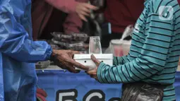 Warga membawa paket takjil gratis di kawasan Cempaka Putih, Jakarta, Selasa (19/4/2022). Sebanyak 360 paket takjil untuk berbuka puasa yang berasal dari donasi warga, organisasi dan instasi dibagikan gratis selama bulan Ramadhan tahun ini. (merdeka.com/Iqbal S. Nugroho)