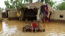 Sejumlah Anak duduk di tempat tidur di depan sebuah rumah yang dilanda banjir setelah hujan lebat di sebuah desa di provinsi Laut Merah Yaman, Houdieda, Jumat, 15 April 2016. (REUTERS/Abdul Jabbar Zeyad)
