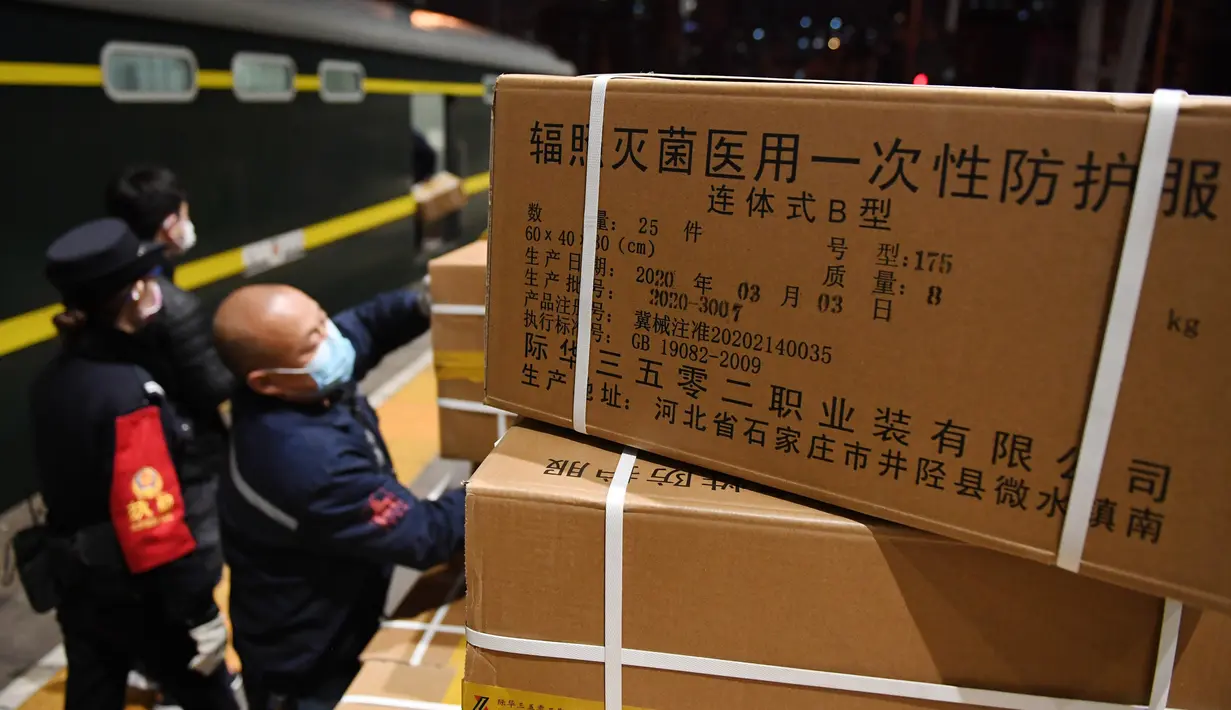 Para staf memuat sejumlah baju pelindung di Stasiun Kereta Barat Beijing di Beijing, ibu kota China (4/3/2020). Total 20.000 baju pelindung disalurkan ke Wuhan guna membantu upaya kota itu memerangi wabah coronavirus baru. (Xinhua/Zhang Chenlin)