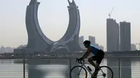 Seorang pria mengendarai sepedanya menjelang turnamen sepak bola Piala Dunia Qatar 2022 di Doha, Rabu (16/11/2022). Piala Dunia 2022 Qatar yang dinobatkan Piala Dunia dalam sejarah sepak bola akan segera mulai pada Minggu (20/11). (AFP/Raul Arboleda)