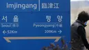Seorang wanita berjalan melalui sebuah papan nama yang menunjukkan jarak ke Ibu Kota Korea Utara Pyongyang dan Ibu Kota Korea Selatan Seoul dari Stasiun Imjingang di Paju, Korea Selatan, Senin (5/3). (AP Photo/Lee Jin-man)
