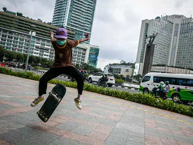 Aksi warga saat bermain skateboard di trotoar Jalan Sudirman-Thamrin, Jakarta, Jumat (5/3/2021). Gubernur DKI Jakarta Anies Baswedan mengizinkan trotoar untuk digunakan sebagai tempat bermain skateboard dengan beberapa kesepakatan. (Liputan6.com/Faizal Fanani)