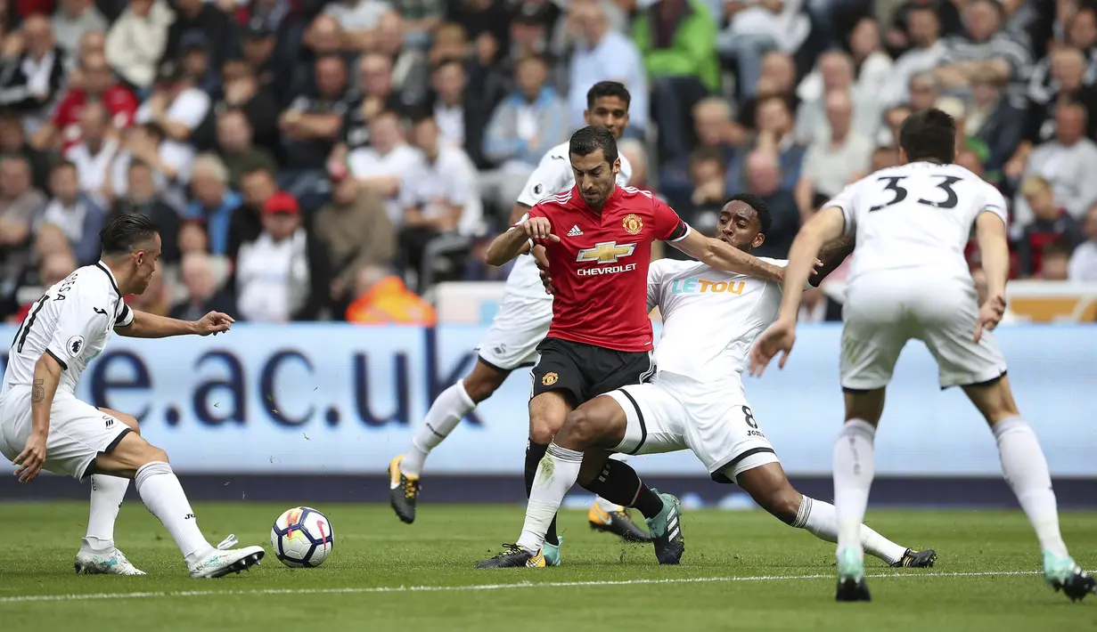 Pemain Manchester United, Henrikh Mkhitaryan berusaha keluar dari kepungan para pemain Swansea City pada lanjutan Premier League di Liberty Stadium, Swansea, (19/8/2017). (Nick Potts/PA via AP)