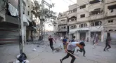 Orang-orang berlari mencari perlindungan setelah serangan Israel yang menargetkan sebuah bangunan di kamp pengungsi Palestina Bureij di Jalur Gaza tengah pada 19 Oktober 2025. (Eyad BABA/AFP)