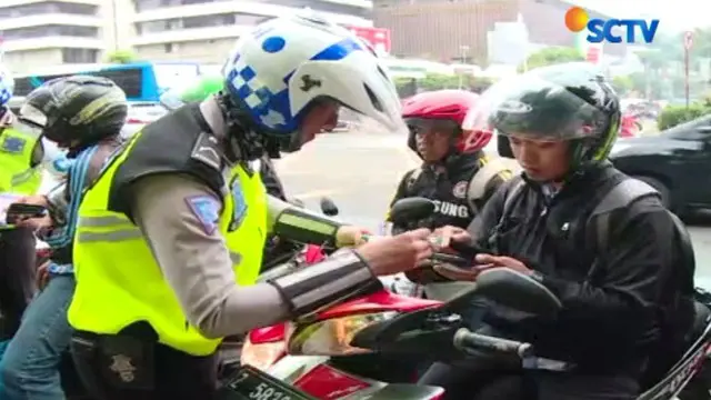 Hari pertama jalur khusus motor, polisi menilang puluhan pengendara motor yang berkendara di jalur mobil.