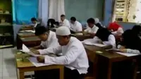 Seorang pegawai negeri sipil (PNS) di Polresta Depok, Jawa Barat di mengikuti Ujian Nasional (UN). 