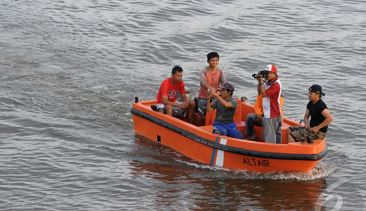 Warga mencoba ingin mengabadikan proses pemindahan bangkai ekor dari Pesawat AirAsia QZ8501, di Pelabuhan Panglima Utar, Kalteng, Minggu (12/01/2015). (Liputan6.com/Andrian M Tunay)