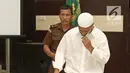 Terdakwa kasus penembakan dr Letty Sultri, dr Helmi tertunduk lesu saat memasuki ruang sidang PN Jakarta Timur, Kamis (29/3). Helmi menjalani sidang perdana dengan agenda pembacaan surat dakwaan oleh JPU. (Liputan6.com/Herman Zakharia)