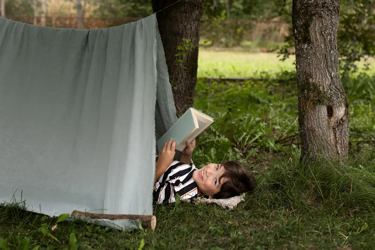 Ilustrasi anak membaca buku sambil tidur di tenda alam terbuka/freepik.com/pikisuperstar