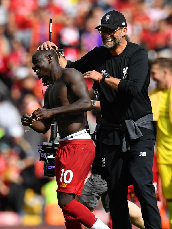 Manajer Liverpool Jurgen Klopp (kanan) memegang kepala Sadio Mane usai tim asuhannya mengalahkan Newcastle United pada laga Liga Inggris di Anfield, Liverpool, Inggris, Sabtu (14/9/2019). Sadio Mane dan Mohamed Salah membawa Liverpool menghajar Newcastle 3-1. (Paul ELLIS/AFP)