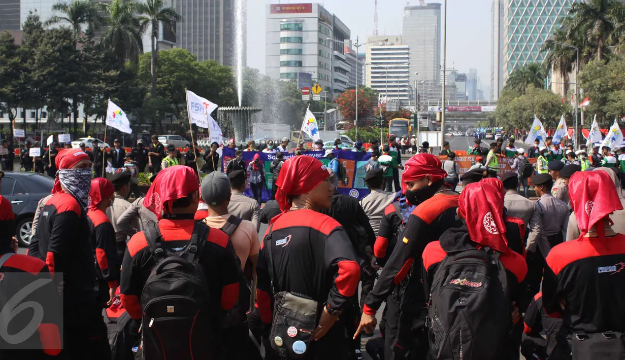 Ratusan buruh tampak berkumpul di sekitar kawasan Patung Kuda, Jakarta, Selasa (1/8/2015). Mereka menuntut pemerintah menghentikan gelombang PHK yang mengancam akibat melemahnya nilai tukar rupiah terhadap dolar. (Liputan6.com/Gempur M Surya)
