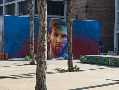 Mural bergambar wajah bintang Barcelona, Lionel Messi, menghiasi sebuah sudut tembok di Barcelona, Catalonia, Sabtu (17/6/2017). (AFP/Josep Lago)