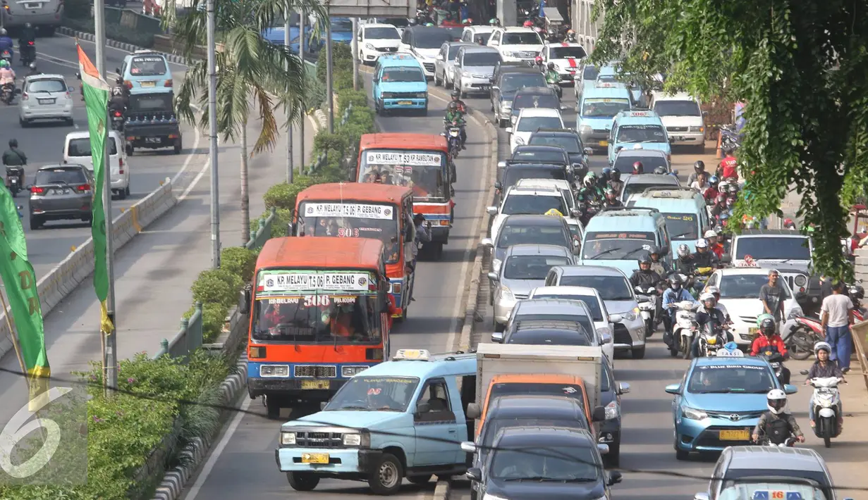 Angkutan umum mencoba menerobos jalur Trans-Jakarta di Jalan Otista Raya, Jakarta, Sabtu (19/11). Rendahnya separator pembatas membuat pengendara dapat leluasa masuk ke jalur tersebut, meskipun berbahaya bagi keselamatan. (Liputan6.com/Immanuel Antonius)