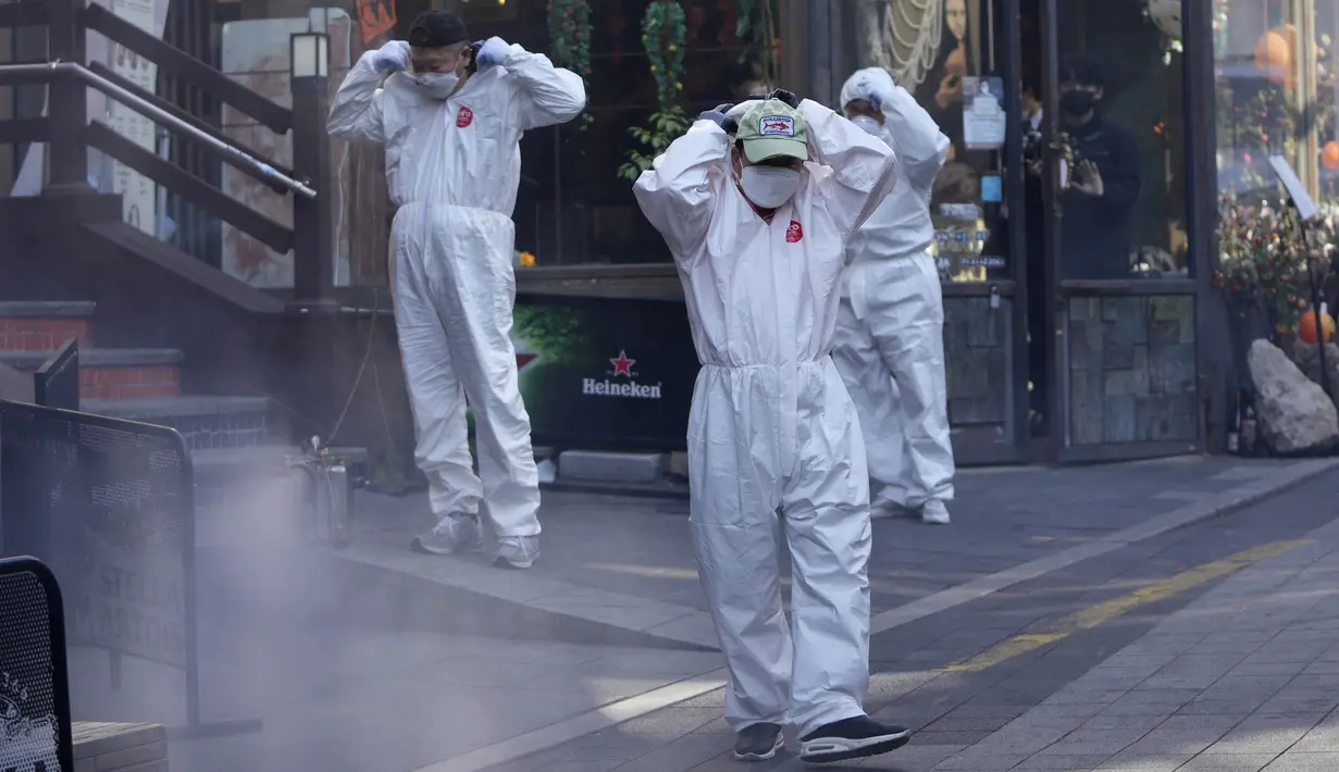 Pejabat kesehatan distrik setempat mengenakan alat pelindung diri saat bersiap untuk mendisinfeksi lorong-lorong sebagai tindakan pencegahan terhadap virus corona COVID-19 di Seoul, Korea Selatan, 29 Oktober 2021. (AP Photo/Lee Jin-man)