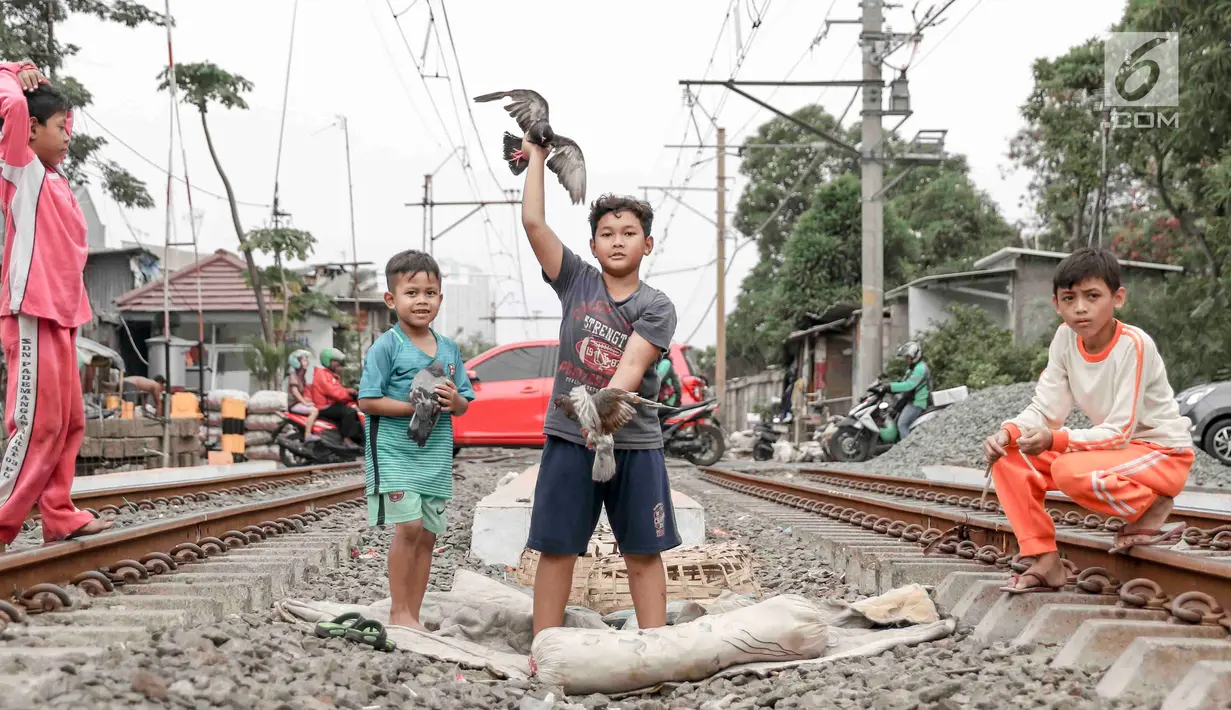 Anak-anak bermain di sekitar rel kereta api di kawasan Pademangan, Jakarta, Kamis (8/11). Kurangnya lahan bermain menyebabkan anak-anak tersebut bermain di tempat yang tidak semestinya dan membahayakan keselamatan. (Liputan6.com/Immanuel Antonius)