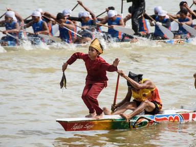 Seorang anak laki-laki menari di bagian depan perahu tradisional selama festival balap perahu Pacu Jalur di Sungai Kuantan, Kabupaten Kuantan Singingi, Provinsi Riau, pada 21 Agustus 2025. (Wahyudi/AFP)