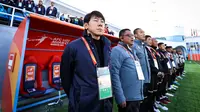Pelatih Timnas Indonesia U-20, Shin Tae-yong bersama tim ofisial berdiri menyanyikan lagu kebangsaan Indonesia Raya sebelum dimulainya laga matchday pertama Grup A Piala Asia U-20 2023 menghadapi Irak di Lokomotiv Stadium, Tashkent, Uzbekistan, Rabu (1/3/2023). (the-afc.com)