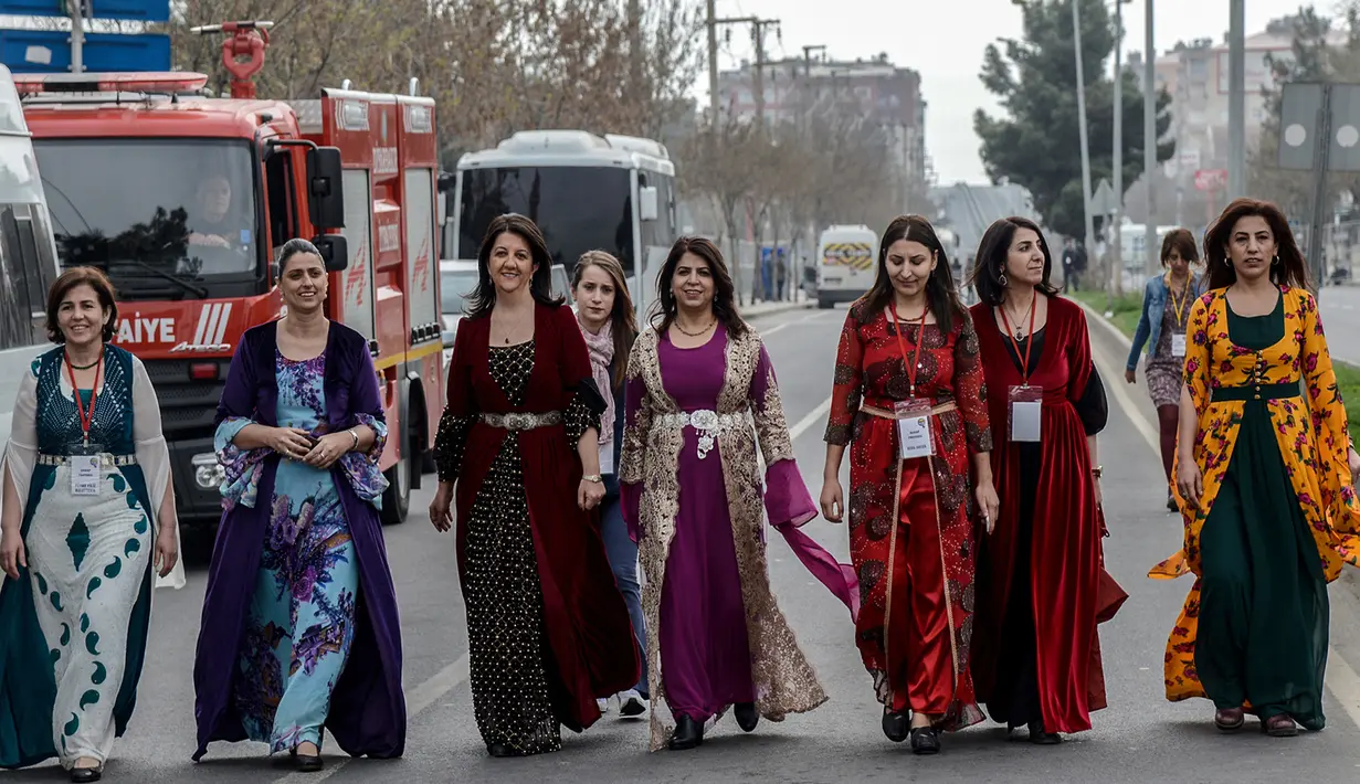 Anggota PM perempuan Partai Demokrasi Rakyat (HDP) dan Pemimpin Wanita HDP Pervin Buldan (tiga kiri) ikut memperingati Women's Day atau Hari Perempuan Internasional di Diyarbakir, Turki, Kamis (8/3). (ILYAS AKENGIN/AFP)