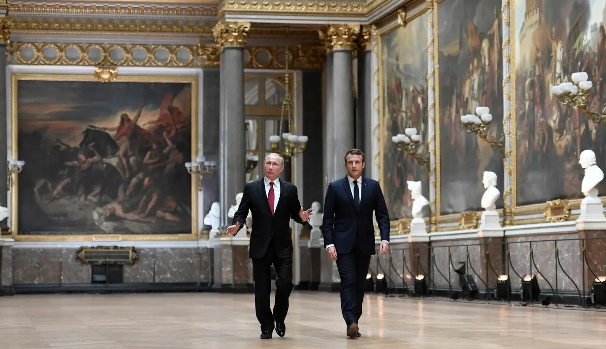 Presiden Prancis Emmanuel Macron mengajak Presiden Rusia, Vladimir Putin berkeliling Gallery of Battles di Istana Versailles, dekat Paris, Senin (29/5). Macron bertemu tatap muka untuk pertama kalinya dengan Putin. (Stephane de Sakutin/Pool Photo via AP)