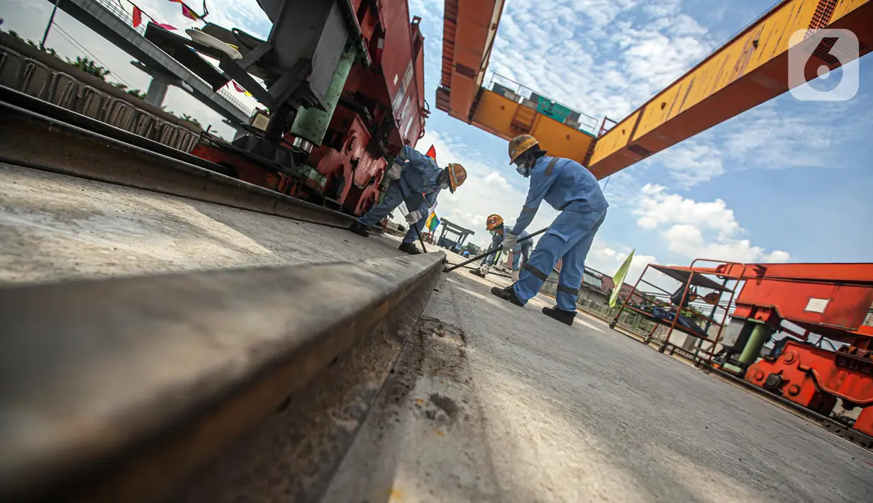 Pekerja Kereta Cepat Jakarta-Bandung (KCJB) menyelesaikan pemasangan girder box Casting Yard #1 di kawasan Jatibening Baru, Bekasi, Jawa Barat, Senin (27/6/2022). Pemasangan girder box yang dilakukan di CY#1 baik arah Jakarta ataupun Bandung sudah rampung sepenuhnya. (Liputan6.com/Faizal Fanani)