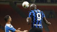 Striker Inter Milan, Romelu Lukaku, menyundul bola saat melawan Napoli pada laga Serie A di Stadion Giuseppe Meazza, Selasa (28/7/2020). Inter Milan menang 2-0 atas Napoli. (AP Photo/Antonio Calanni)