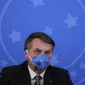 Presiden Brasil Jair Bolsonaro mengenakan masker saat konferensi pers mengenai pandemi virus corona COVID-19 di Istana Planalto, Brasilia, Brasil, 20 Maret 2020. Bolsonaro kerap menganggap ringan COVID-19 kendati Brasil menjadi salah satu pusat penyebaran COVID-19 dunia. (Sergio LIMA/AFP)