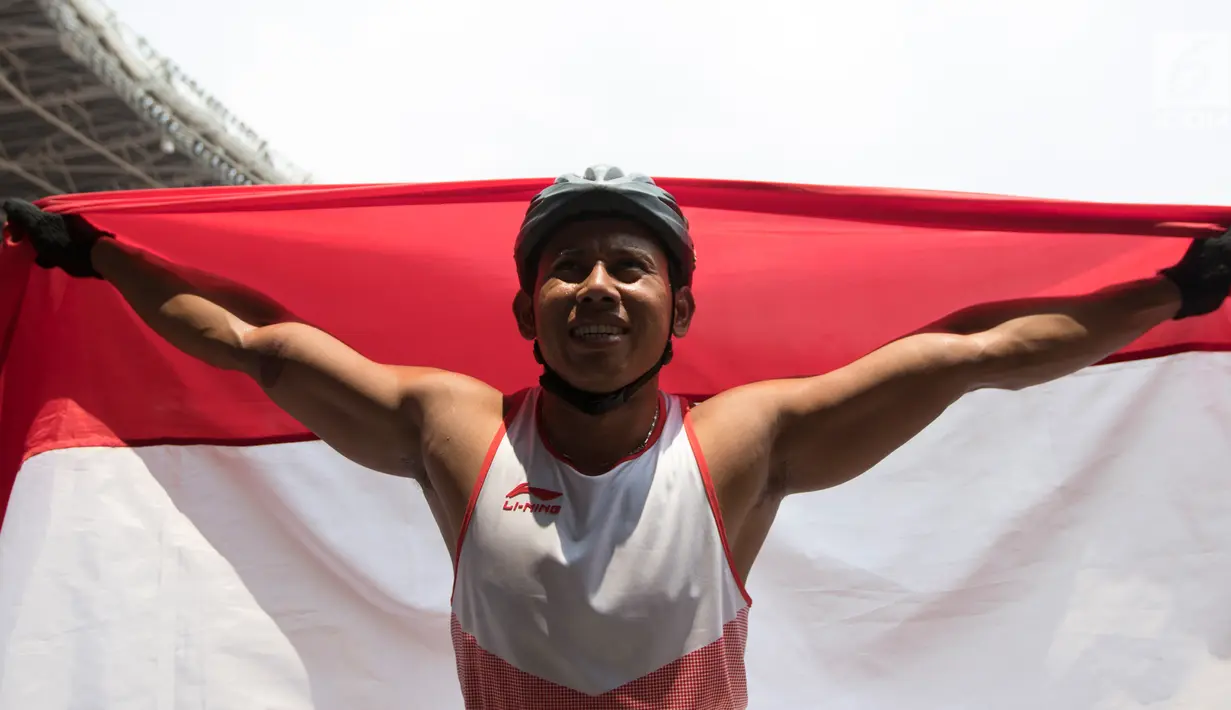 Pebalap kursi roda Indonesia, Jaenal Aripin, berselebrasi usai meraih medali perak Asian Para Games pada cabang atletik nomor balap kursi roda 200 meter T 54 di SUGBK, Jumat (12/10). Jaenal mencatatkan waktu 26,21 detik. (Bola.com/Vitalis Yogi Trisna)