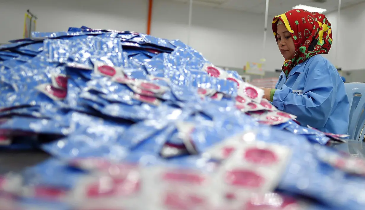 Pekerja mengemas kondom rasa nasi lemak di pabrik Karex Industries, Malaysia (20/9). Perusahaan kondom terbesar dunia asal Malaysia, Karex Industries telah memproduksi kondom dengan rasa makanan khas Negeri Jiran, nasi lemak. (AFP Photo/Manan Vatsyayana)