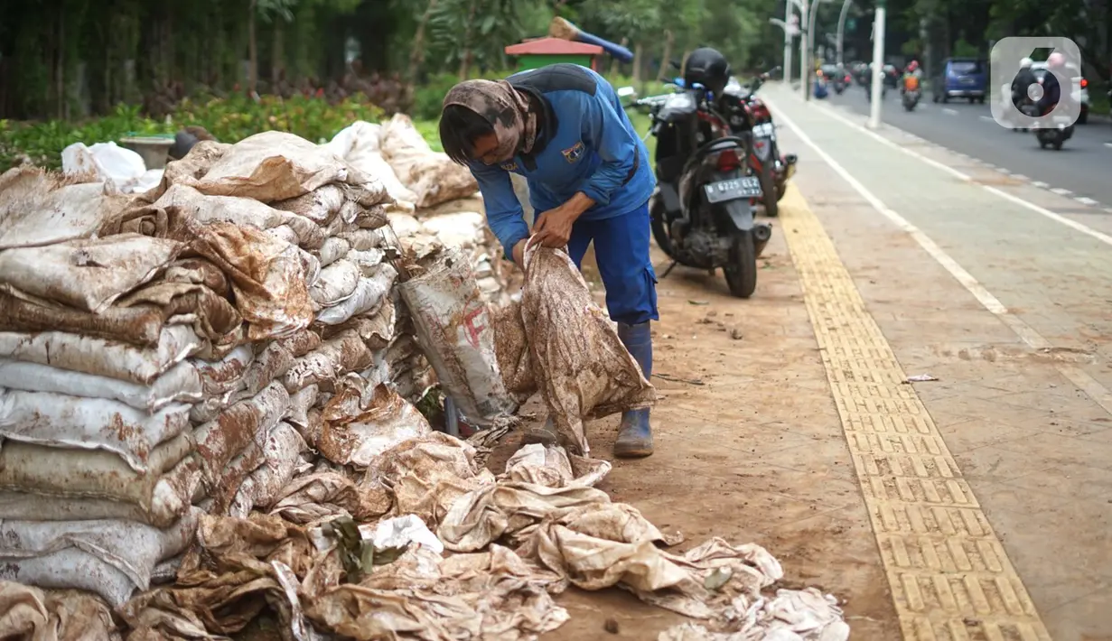 Petugas menyelesaikan pembuatan sumur resapan di kawasan Cempaka Putih, Jakarta, Rabu (25/11/2020). Sebanyak 14 lubang sumur resapan yang dibangun di ruas Jalan Jenderal Ahmad Yani dan Cempaka Putih Barat 21 ditargetkan dapat selesai akhir Desember nanti. (Liputan6.com/Immanuel Antonius)