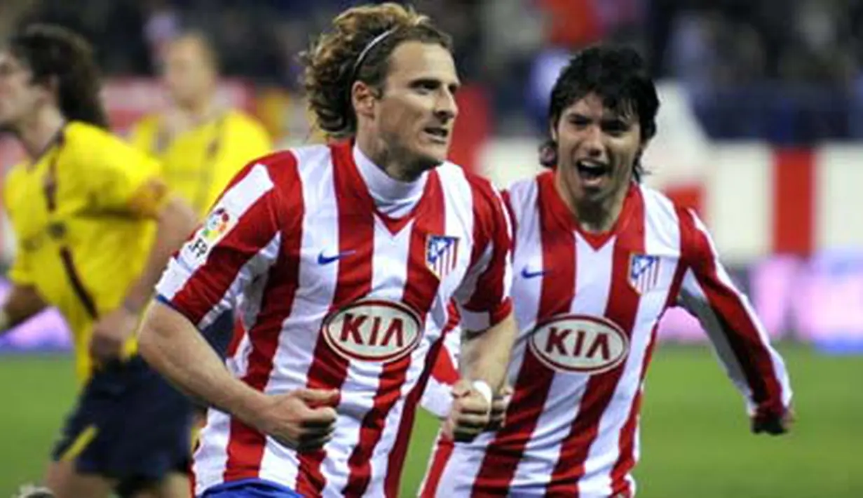 Atletico de Madrid&#039;s forward Diego Forlan celebrates his goal against FC Barcelona with teammate Kun Aguerro during their Liga football match at Vicente Calderon stadium in Madrid on March 1, 2009. AFP PHOTO/ PIERRE-PHILIPPE MARCOU 