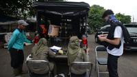 Petugas Satpol PP mendata warga yang terjaring razia protokol kesehatan COVID-19 di Kebon Nanas, Jakarta, Selasa (15/6/2021). Saat kasus positif Covid-19 di Jakarta meningkat, masih banyak warga yang belum menjalankan protokol kesehatan, salah satunya mengenakan masker. (merdeka.com/Imam Buhori)