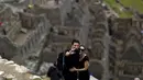 Pasangan wisatawan berselfie di reruntuhan kerajaan inca di pegunungan Machu Picchu , Peru, Rabu (12/8/2015).  Pemerintah setempat membatasi wisatawan yang masuk ke Machu Picchu yang hanya menerima 2.500 wisatawan. (REUTERS/Pilar Olivares)