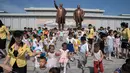 Anak-anak berjalan di depan patung pemimpin Korea Utara Kim Il Sung (kiri) dan Kim Jong Il (kanan), setelah meletakkan bunga untuk menandai peringatan 24 tahun kematian Kim Il Sung, di bukit Mansu, Pyongyang, Minggu (8/7). (AP Photo/Andrew Harnik, Pool)