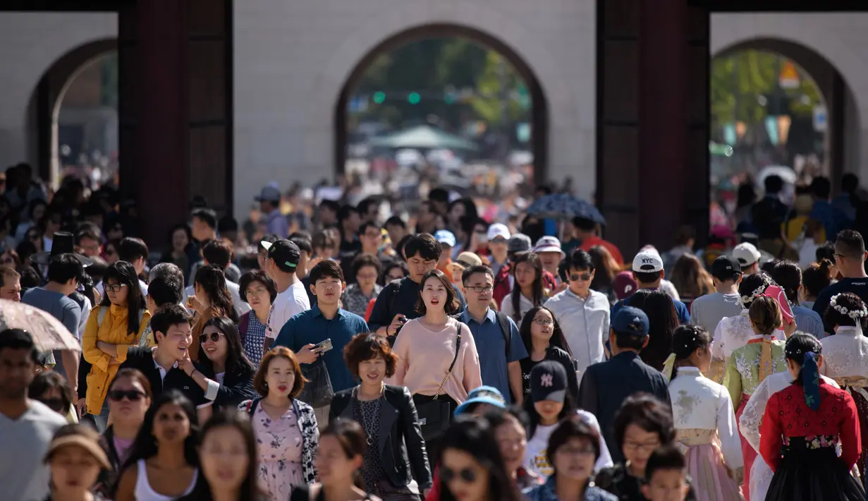 Wisatawan mengunjungi istana Gyeongbokgung pada hari terakhir liburan Chuseok di Seoul, Rabu (26/9). Biasanya, masyarakat Korea akan menggunakan momen ini untuk berkumpul dengan para keluarga. (AFP PHOTO / Ed JONES)