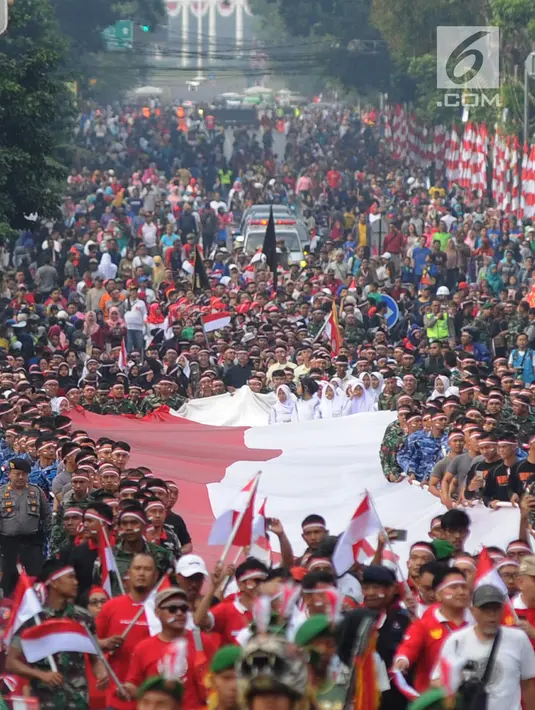 Anggota TNI POLRI  bersama warga masyarakat membawa bendera raksasa berukuran panjang 117 meter dan lebar 5 meter saat gelaran Festival Merah-Putih (FMP) 2018 di kawasan Air Mancur, Bogor ,  Minggu (5/8). (Merdeka.com/Arie Basuki)